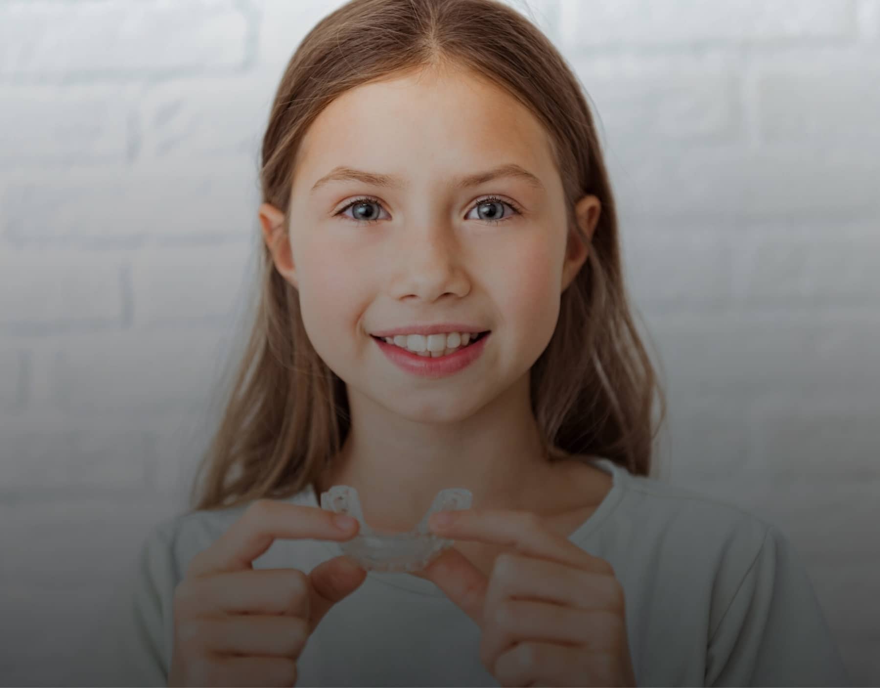 child holding aligners