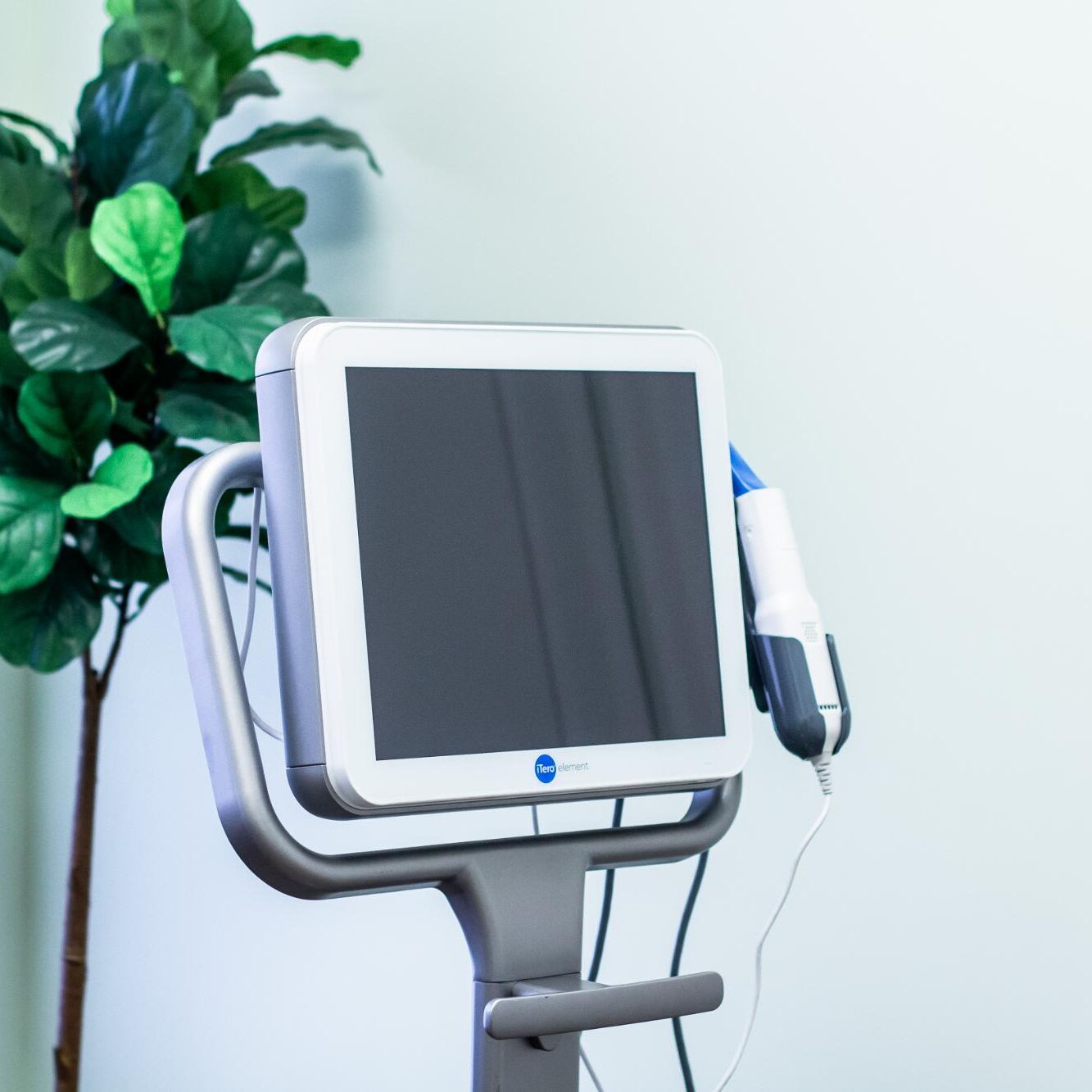 Advanced orthodontic technology with a touchscreen monitor and dental tool, highlighting White Orthodontics' commitment to innovative treatments and personalized patient care.