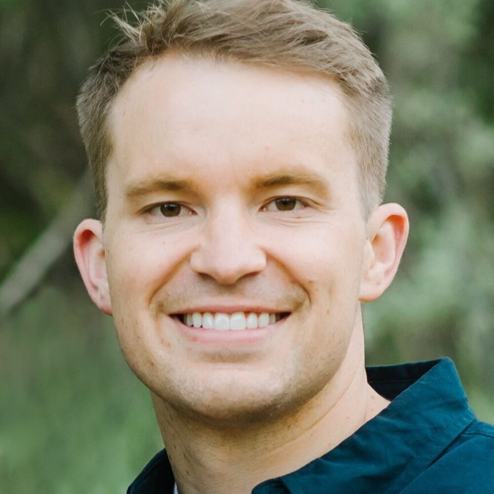 Dr. Stephen White smiling, showcasing a confident smile, with a blurred natural background, representing White Orthodontics in Eagle Mountain, Utah.
